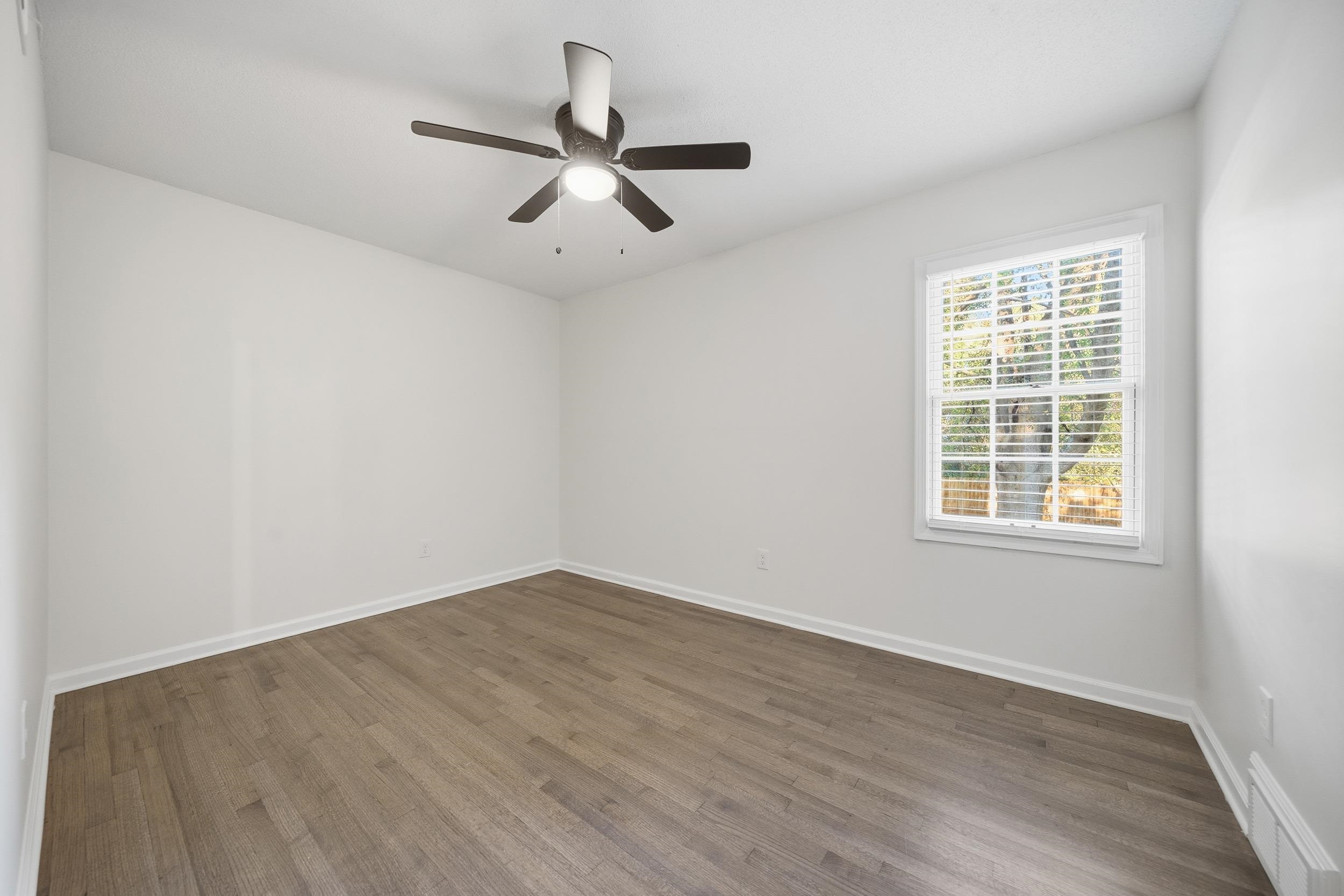 6246 Quince Road Memphis, TN 38119 - Photo 19 of 27 an empty room with wooden floor fan and windows