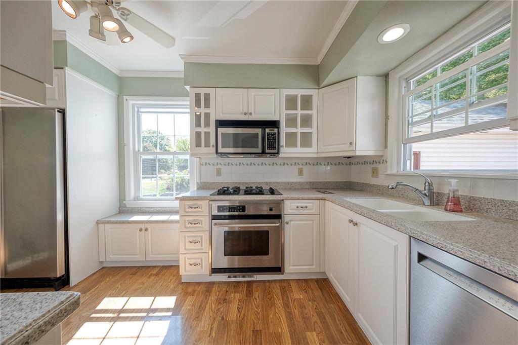 9765 Grosick Road Pittsburgh, PA 15237 - Photo 7 of 33 a kitchen with a stove a sink and a microwave