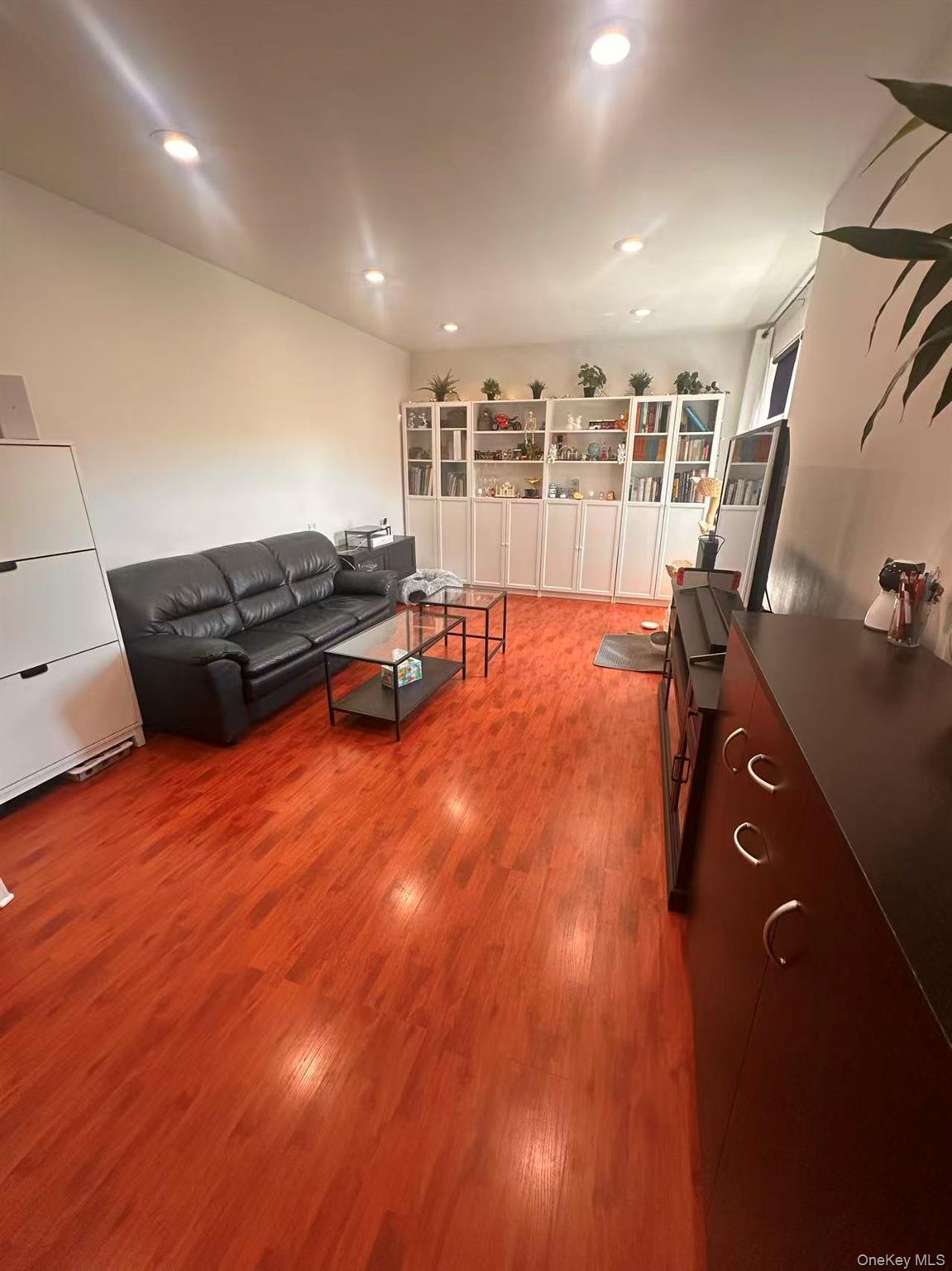 139-15 28th Road, Unit 6G Queens, NY 11354 - Photo 4 of 20 a living room with furniture and wooden floor