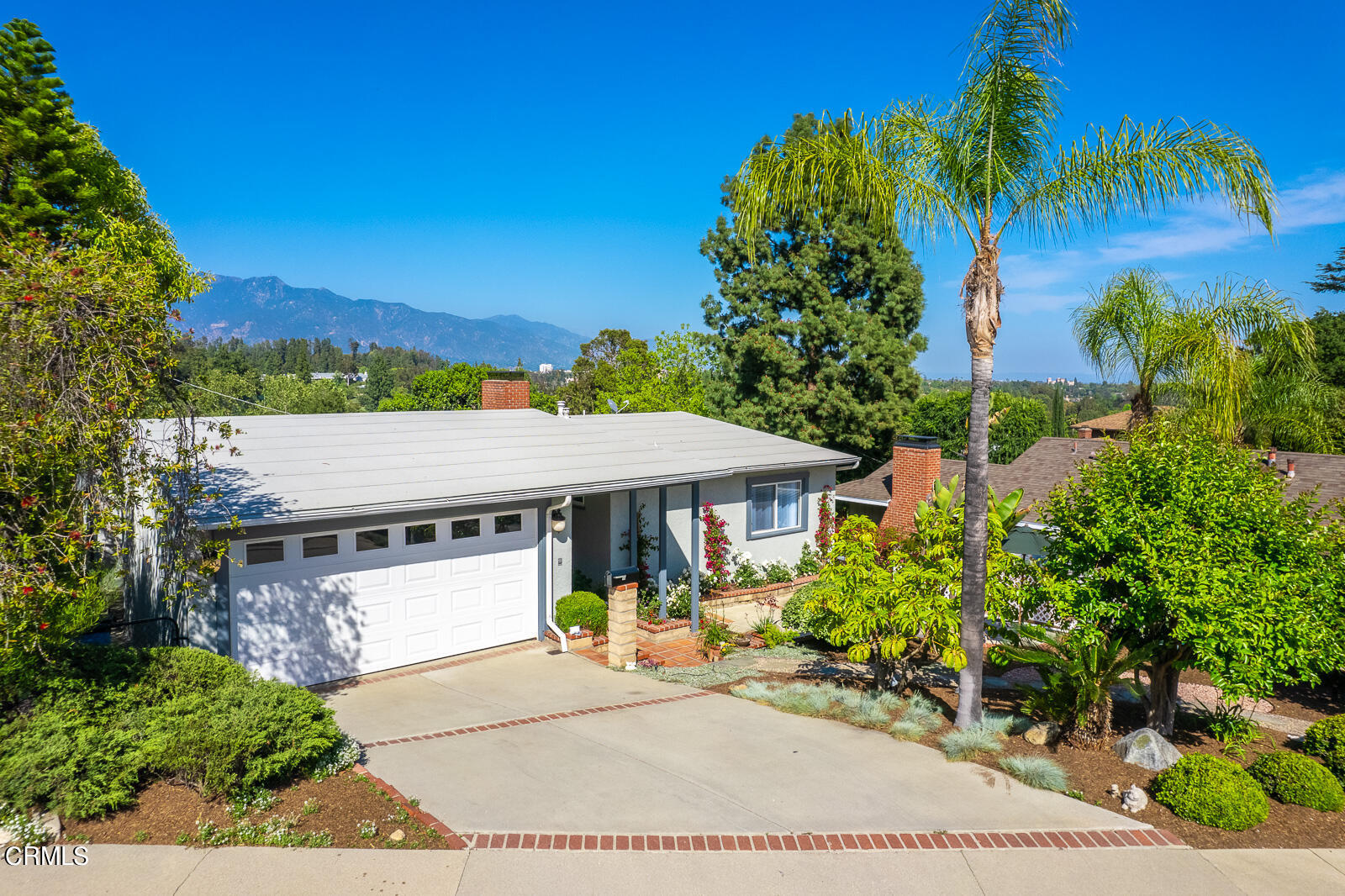 an aerial view of a house with garden space and a patio