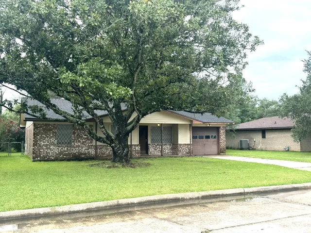 a front view of a house with a garden and trees