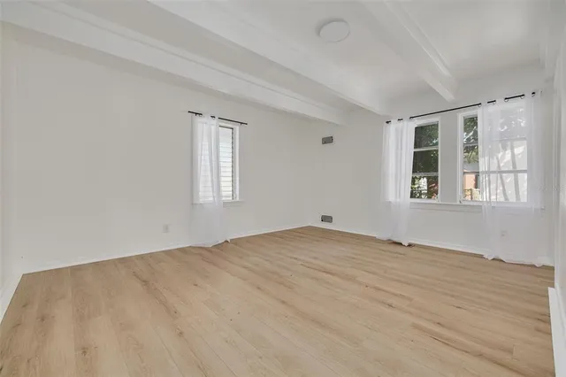 a view of a white house with a big yard and large tree