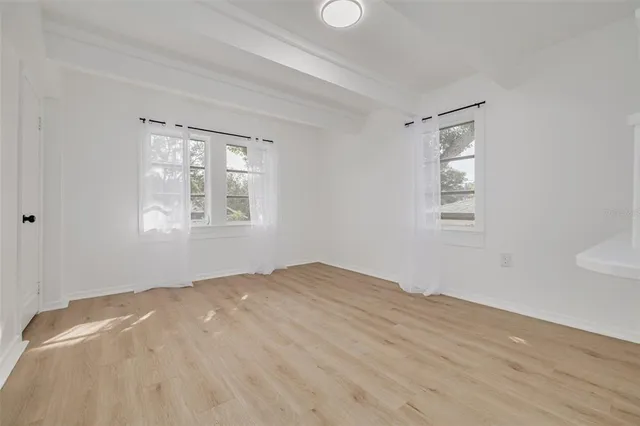 a view of a room with wooden floor and windows