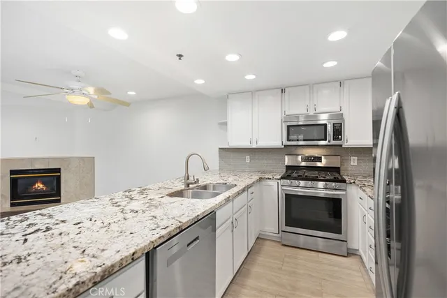 a kitchen with stainless steel appliances granite countertop a refrigerator a stove a sink and a granite counter tops