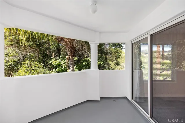 an empty room with wooden floor and window