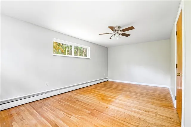 an empty room with a window and a ceiling fan