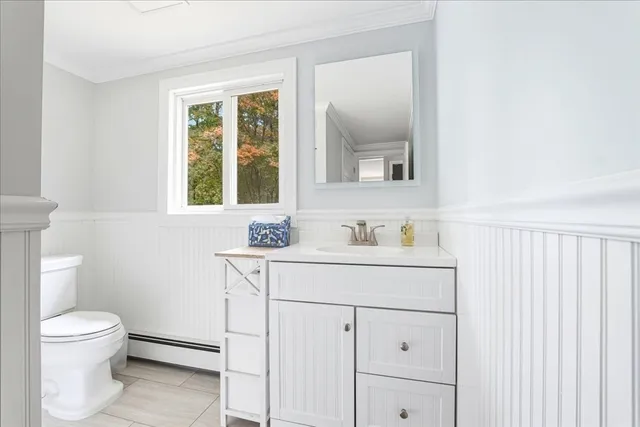 a bathroom with a sink a toilet and a window