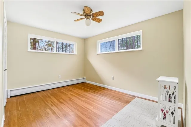 a view of a big room with wooden floor and ceiling fan