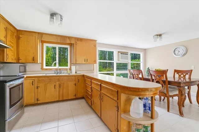 a large kitchen with kitchen island a large window in it