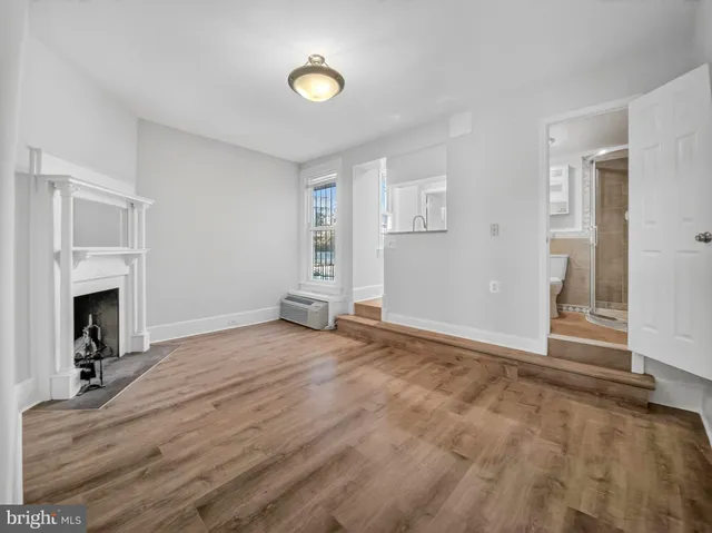 a view of empty room with fireplace and fan
