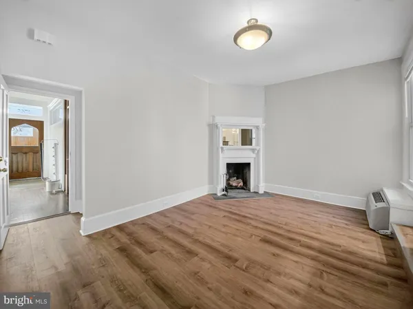 a view of empty room with wooden floor and fireplace