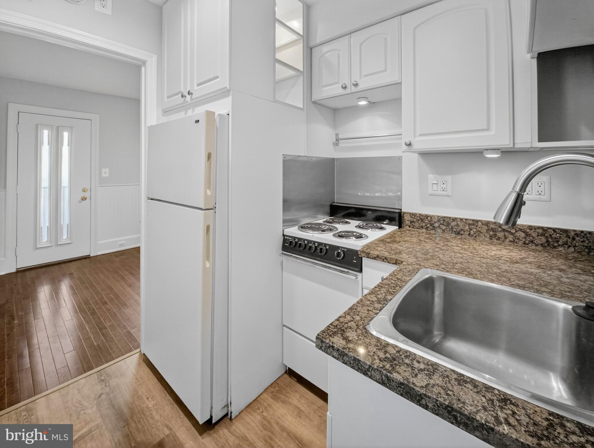 1765 U Street Northwest, Unit 2 Washington, DC 20009 - Photo 9 of 16 a kitchen with granite countertop a sink a refrigerator and a stove