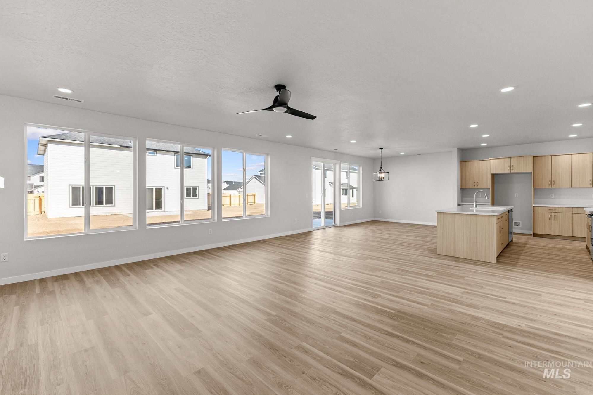 13708 Judson Street Caldwell, ID 83607 - Photo 11 of 29 Unfurnished living room with light wood-type flooring, a ceiling fan, and a chandelier