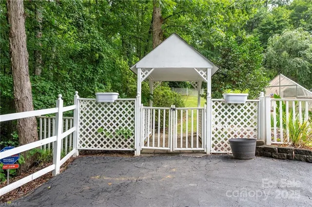 a view of a wooden house with a small yard and wooden fence