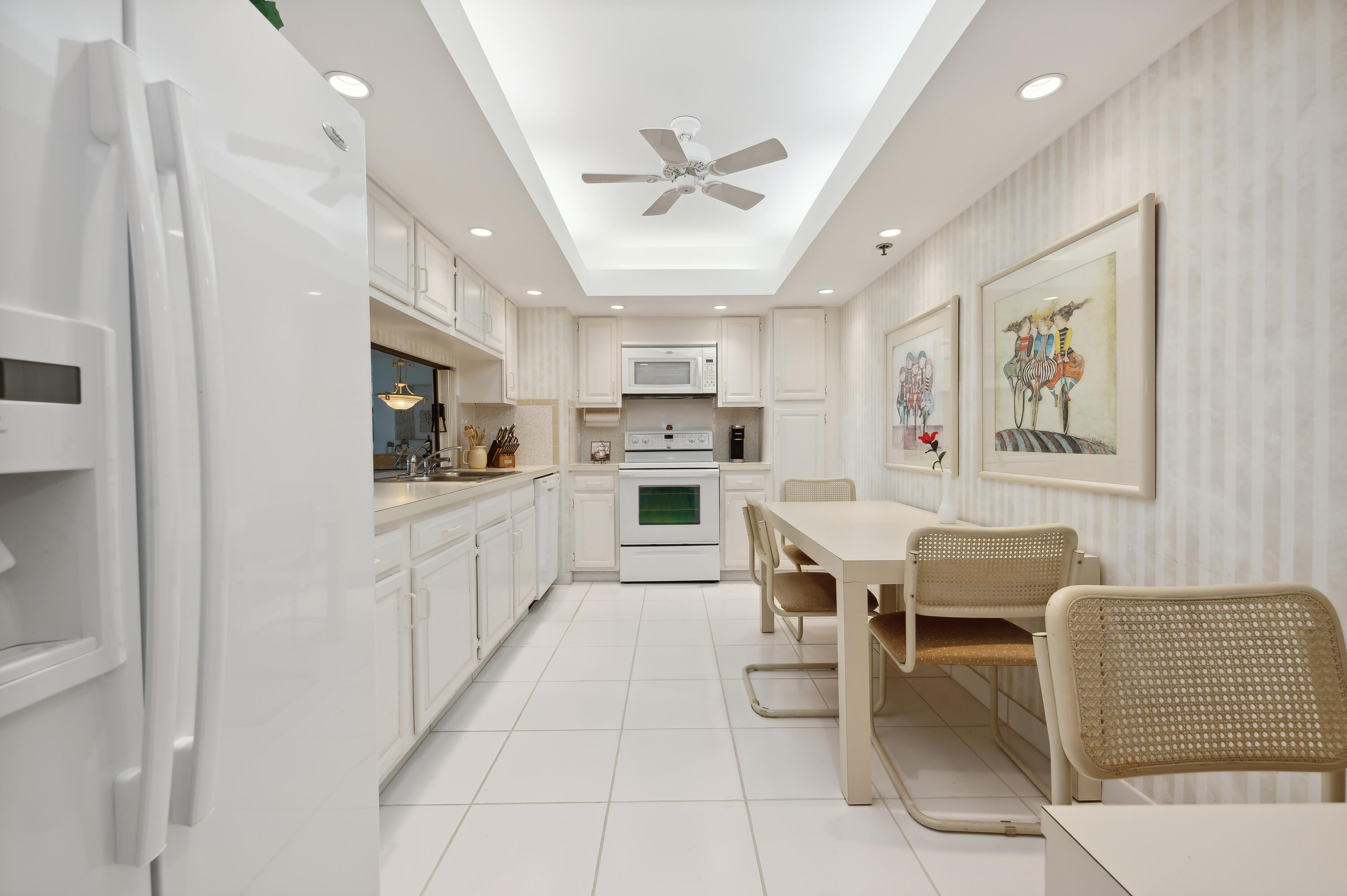 4748 South Ocean Boulevard, Unit 206 Highland Beach, FL 33487 - Photo 15 of 31 a kitchen with stainless steel appliances kitchen island granite countertop a refrigerator and microwave