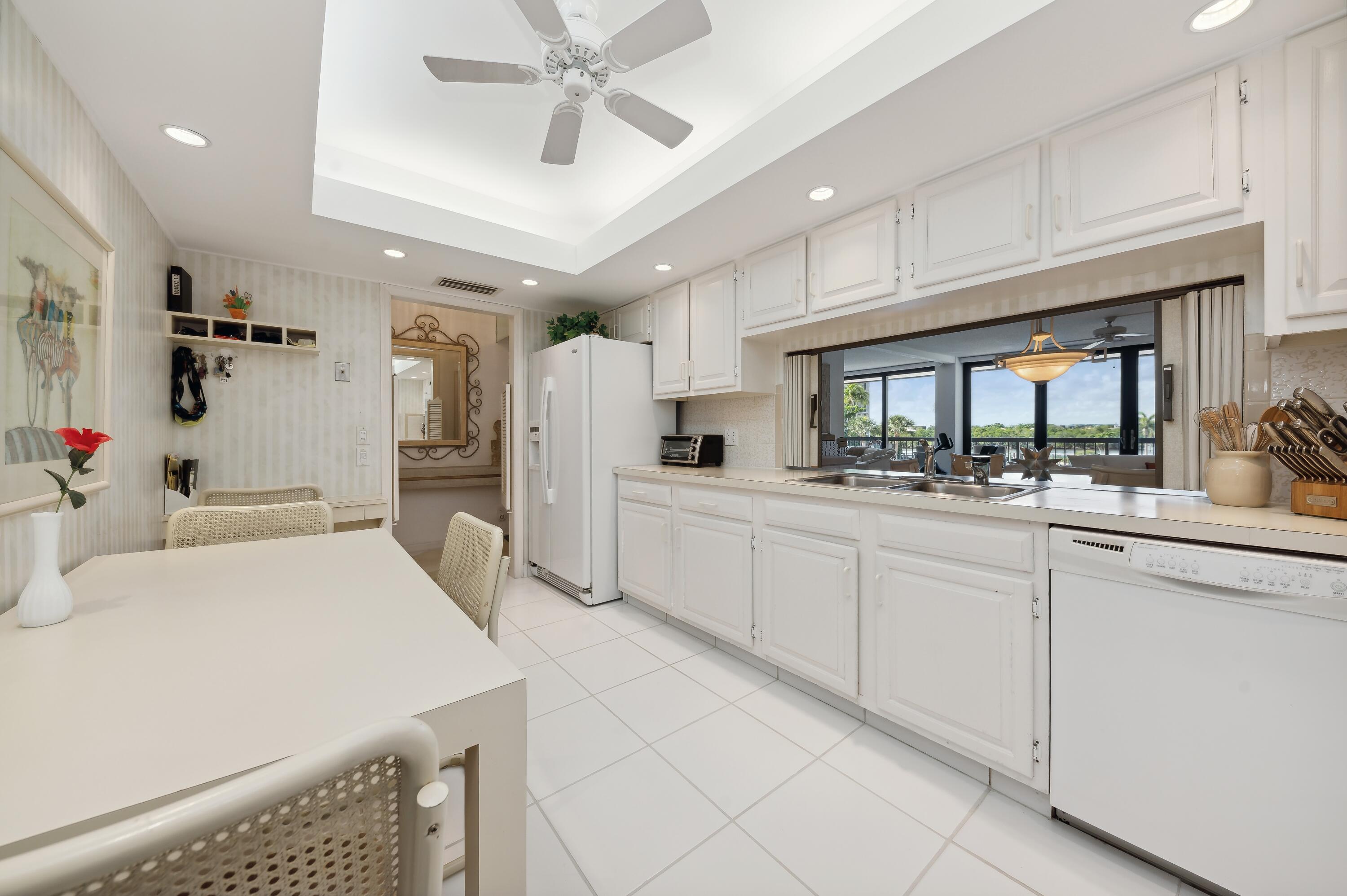 4748 South Ocean Boulevard, Unit 206 Highland Beach, FL 33487 - Photo 16 of 31 a kitchen with white cabinets and white appliances