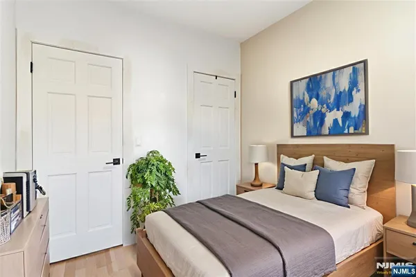 a bedroom with a bed and a painting on the wall