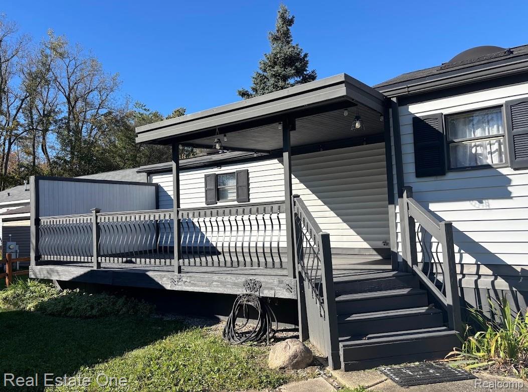 786 Chestnut Street Fowlerville, MI 48836 - Photo 17 of 19 Covered deck with decorative railing, exterior siding, and window with shutters