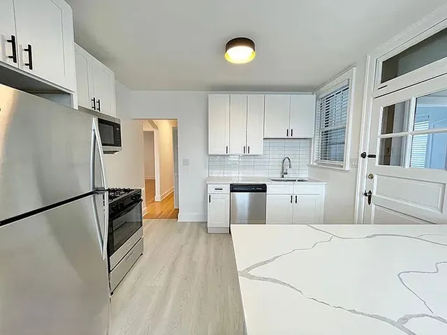 a kitchen with stainless steel appliances a refrigerator sink and cabinets