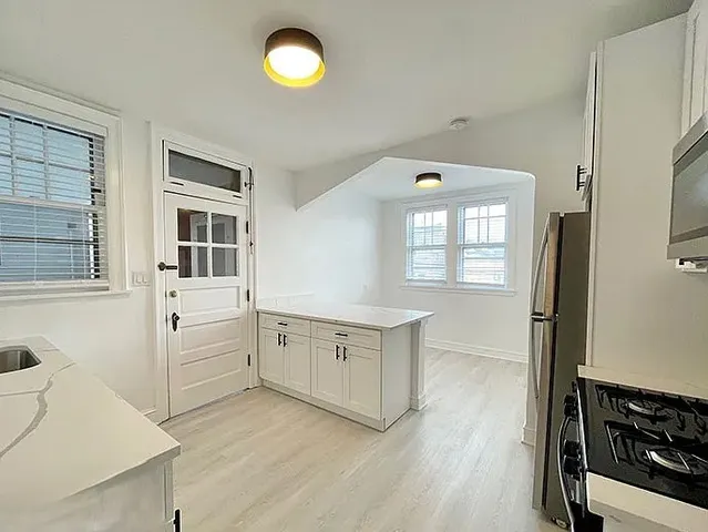 a hall with wooden floor and cabinets