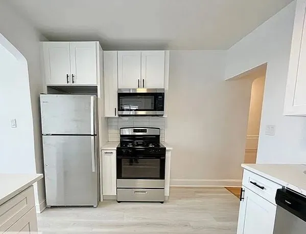 a kitchen with a refrigerator and a stove
