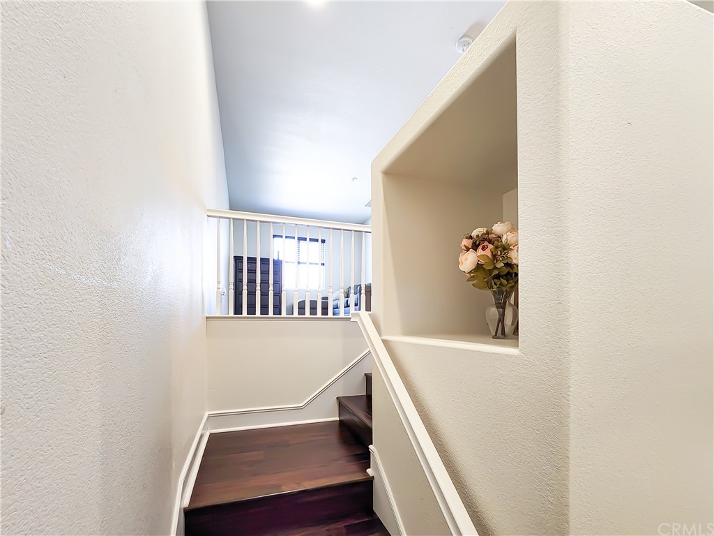8024 Tulsa Place, Unit 107 Rancho Cucamonga, CA 91730 - Photo 12 of 35 a view of staircase with lots of frames on wall and a window