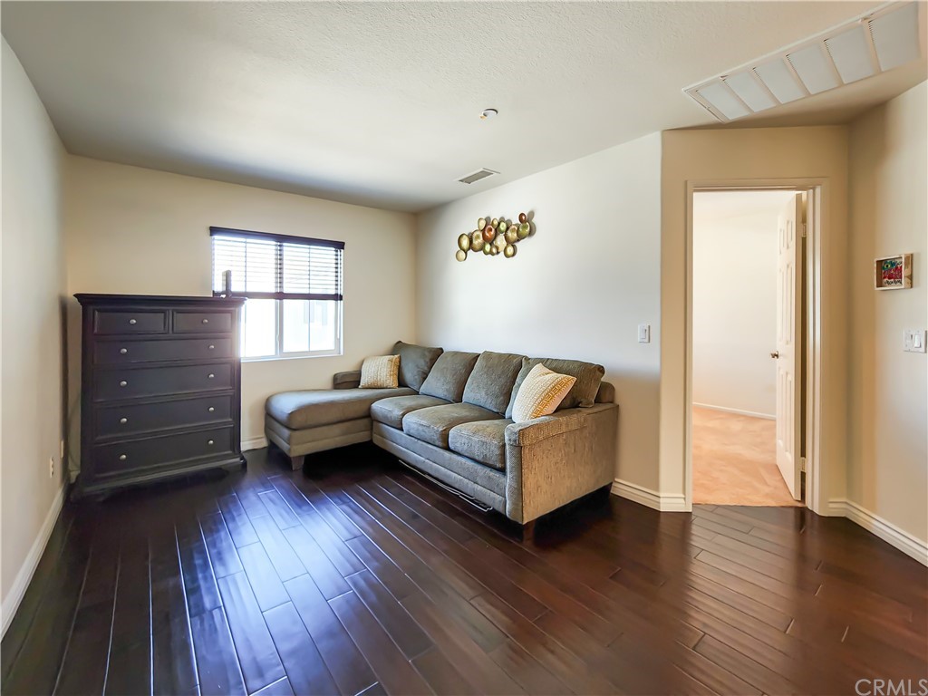 8024 Tulsa Place, Unit 107 Rancho Cucamonga, CA 91730 - Photo 14 of 35 a living room with furniture and a wooden floor