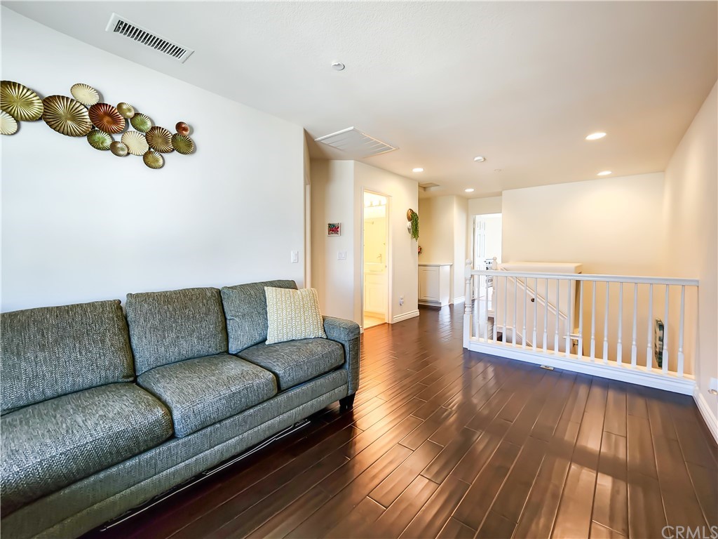 8024 Tulsa Place, Unit 107 Rancho Cucamonga, CA 91730 - Photo 15 of 35 a living room with furniture and wooden floor