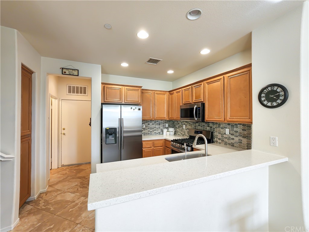 8024 Tulsa Place, Unit 107 Rancho Cucamonga, CA 91730 - Photo 2 of 35 a kitchen with stainless steel appliances a refrigerator and a sink