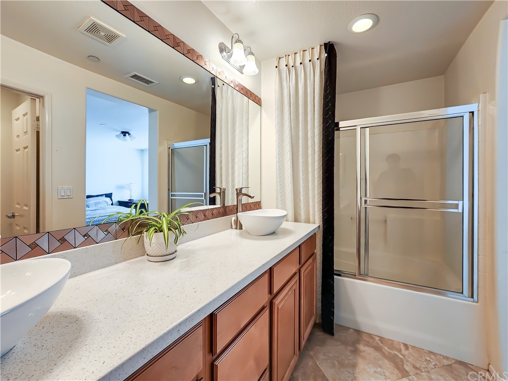 8024 Tulsa Place, Unit 107 Rancho Cucamonga, CA 91730 - Photo 25 of 35 a bathroom with a double vanity sink and a mirror
