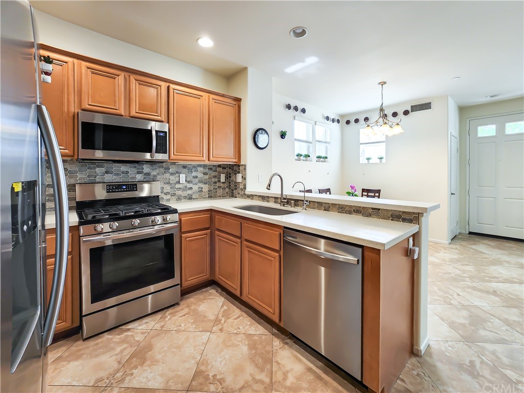 8024 Tulsa Place, Unit 107 Rancho Cucamonga, CA 91730 - Photo 4 of 35 a kitchen with stainless steel appliances granite countertop a stove sink microwave and cabinets