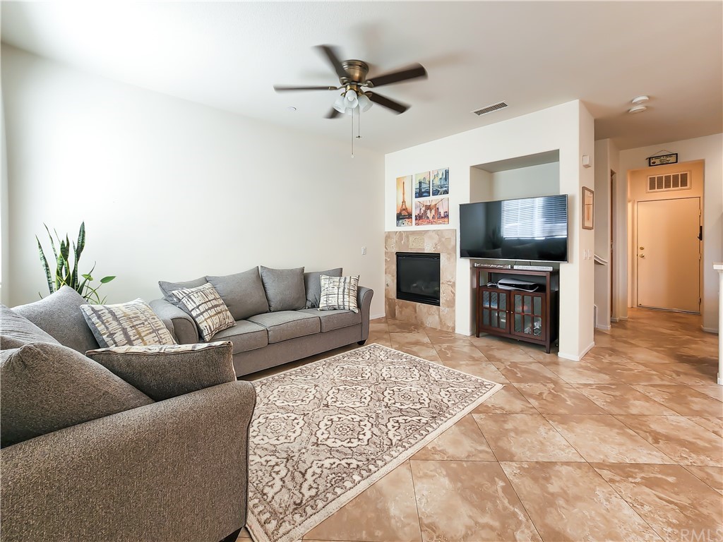 8024 Tulsa Place, Unit 107 Rancho Cucamonga, CA 91730 - Photo 6 of 35 a living room with furniture a flat screen tv and a fireplace