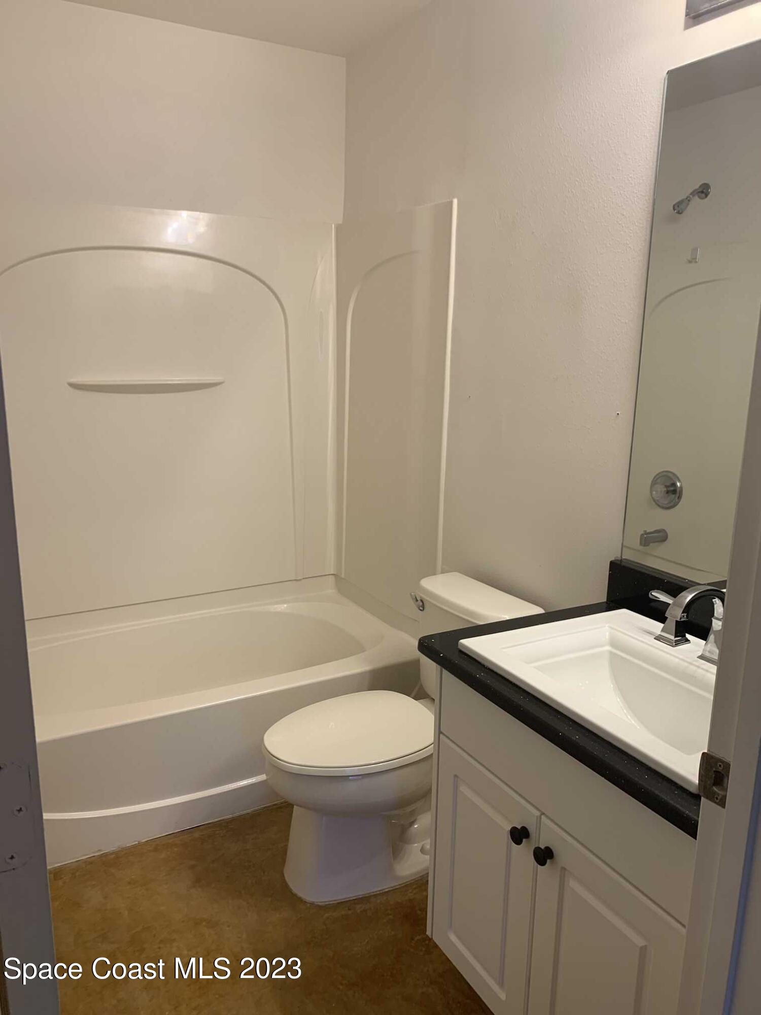 1030 Luminary Circle, Unit 106 Melbourne, FL 32901 - Photo 11 of 14 a bathroom with a sink a toilet and shower