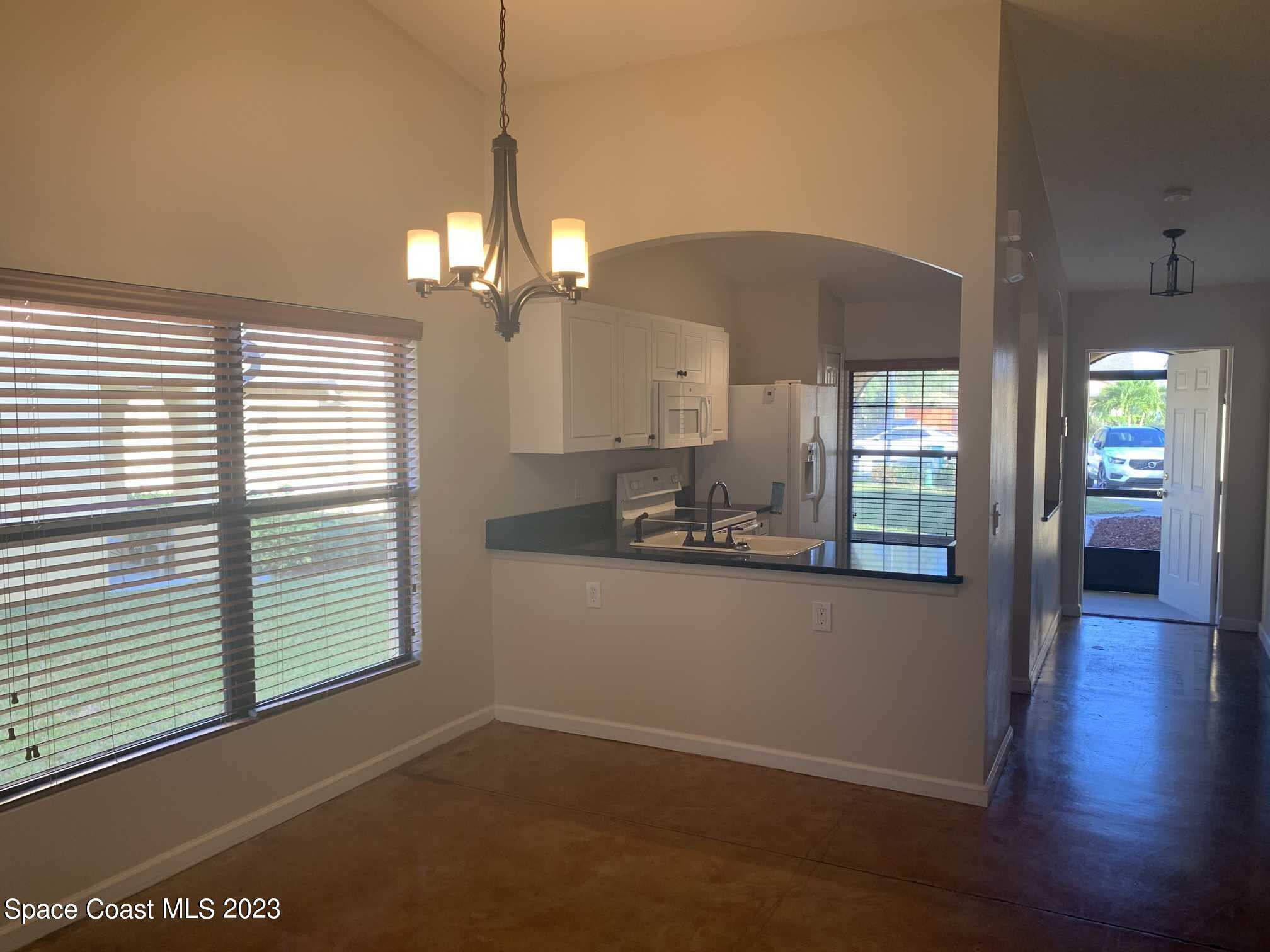 1030 Luminary Circle, Unit 106 Melbourne, FL 32901 - Photo 8 of 14 a kitchen with granite countertop a stove a sink and a window