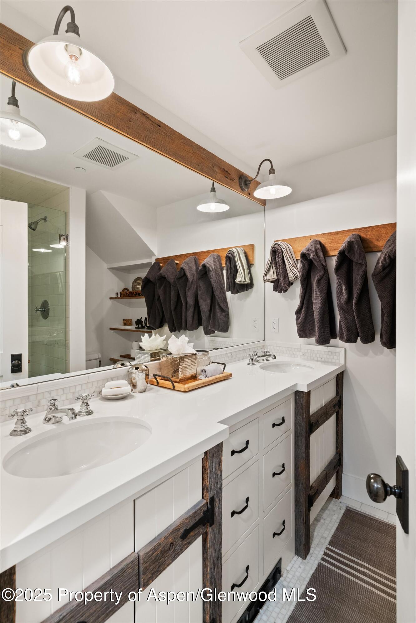 9555 Castle Creek Road Aspen, CO 81612 - Photo 26 of 42 a bathroom with a double vanity sink and a mirror
