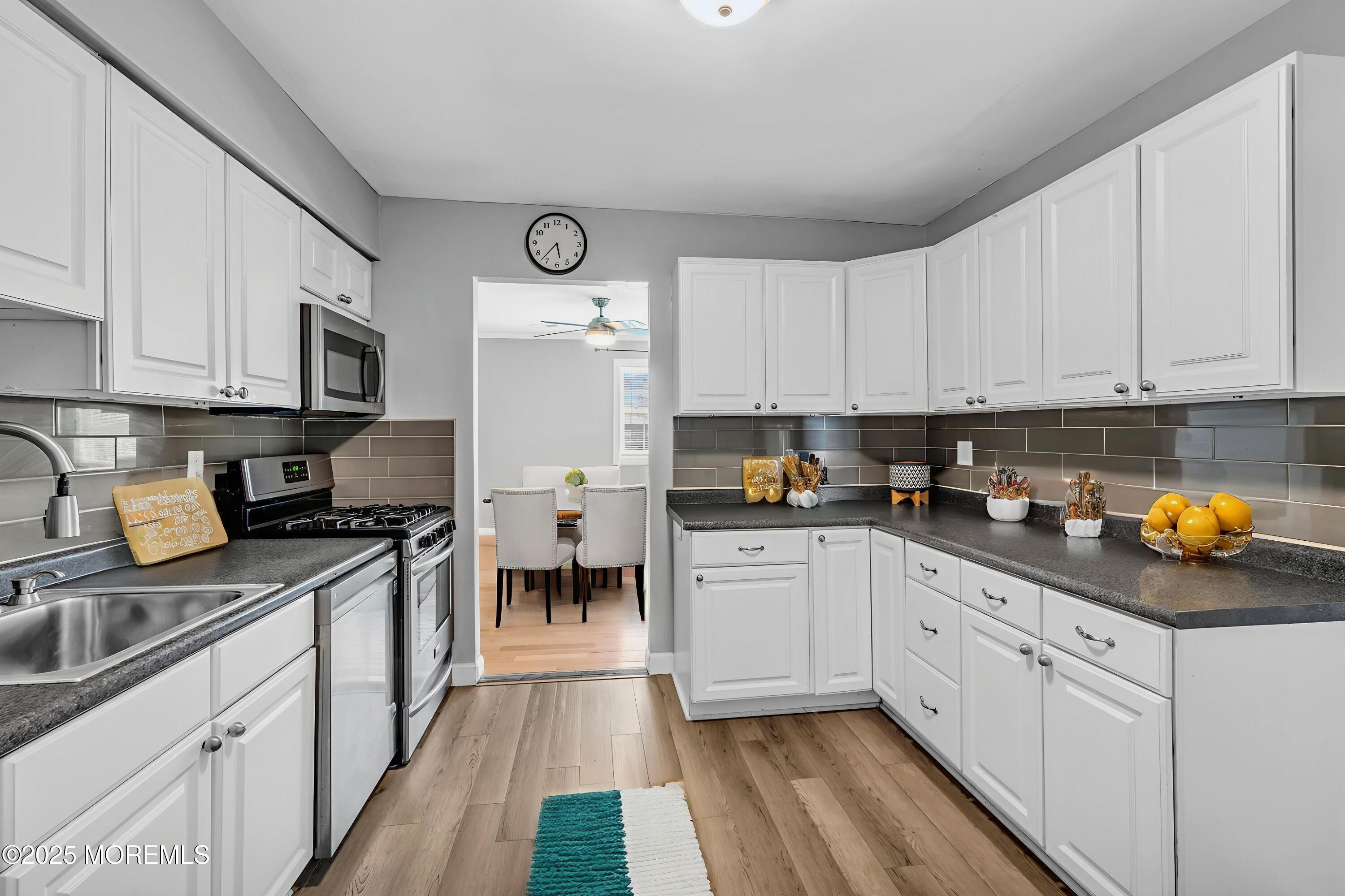 94 Greenwood Loop Road Brick, NJ 08724 - Photo 5 of 22 a kitchen with stainless steel appliances granite countertop a stove top oven a sink a refrigerator and white cabinets