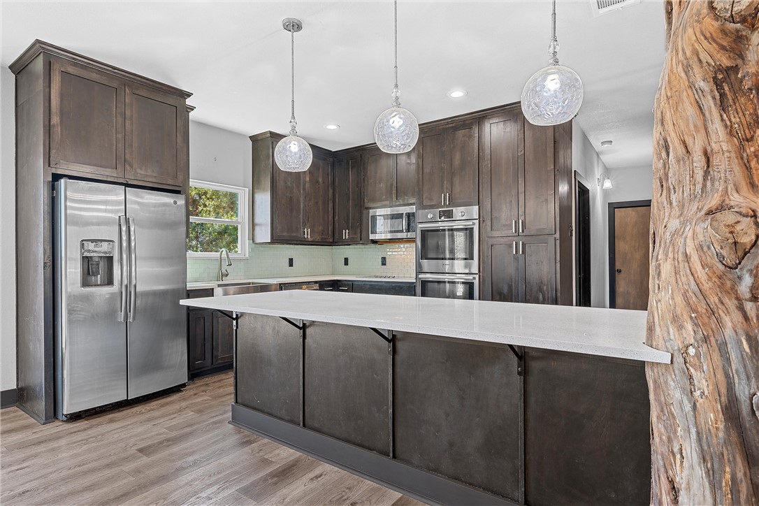 778 Rivercrest Road Valley Mills, TX 76689 - Photo 15 of 66 a large kitchen with stainless steel appliances a refrigerator and a wooden floor