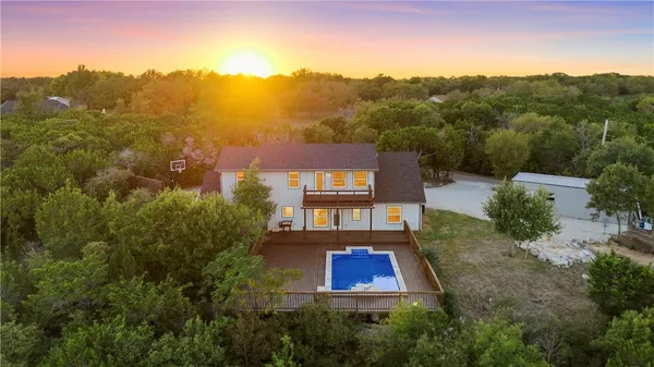 a kitchen with stainless steel appliances kitchen island granite countertop a dining table chairs and wooden floor