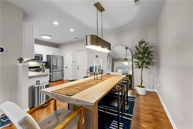a kitchen with stainless steel appliances a kitchen island a stove a table and chairs