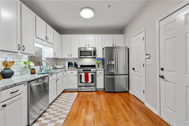 a kitchen with stainless steel appliances a refrigerator sink and microwave