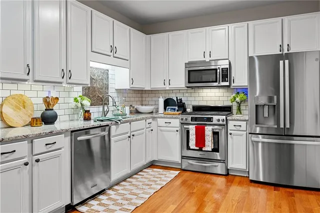 a kitchen with stainless steel appliances granite countertop a refrigerator sink and stove