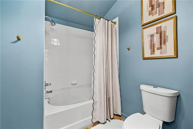 a white toilet sitting next to a bath tub