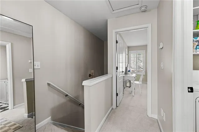 a view of a hallway with a dining table and chairs