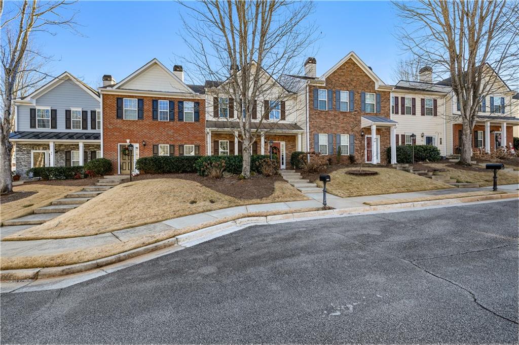 100 Portico Place Newnan, GA 30265 - Photo 37 of 51 a view of a white house with large windows next to a road