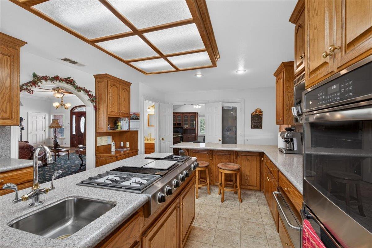 30324 Lone Tree Road Oakdale, CA 95361 - Photo 18 of 74 a kitchen with stainless steel appliances granite countertop a stove and a sink