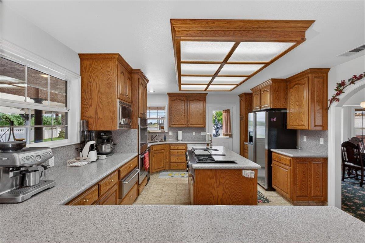 30324 Lone Tree Road Oakdale, CA 95361 - Photo 19 of 74 a kitchen with sink refrigerator and large window