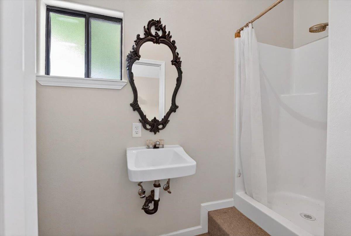 30324 Lone Tree Road Oakdale, CA 95361 - Photo 49 of 74 a bathroom with a sink a mirror and a shower
