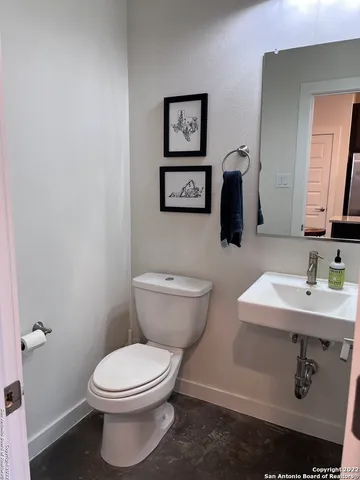 a bathroom with a toilet a sink and mirror