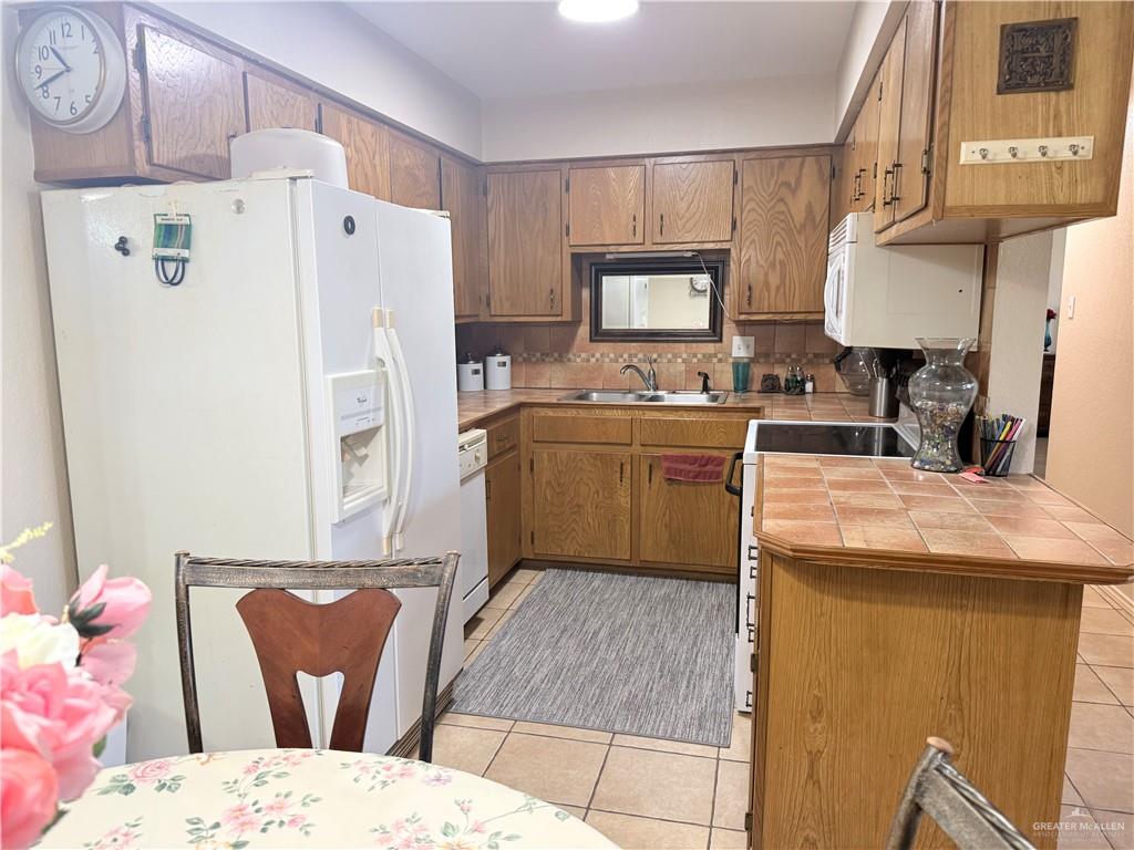 807 East 21st Street, Unit 8 Mission, TX 78572 - Photo 6 of 15 a kitchen with stainless steel appliances kitchen island granite countertop refrigerator sink and cabinets