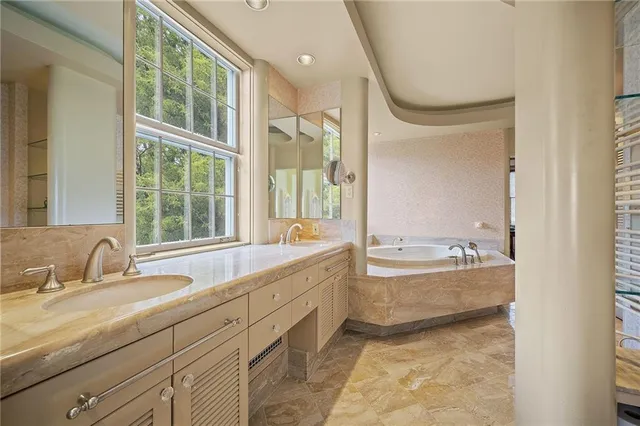 a bathroom with a tub sink and mirror